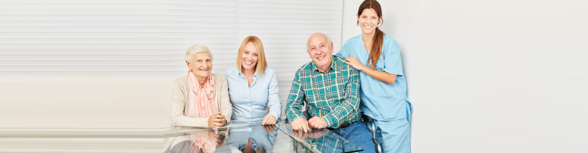 senior couple with adult woman and caregiver smiling